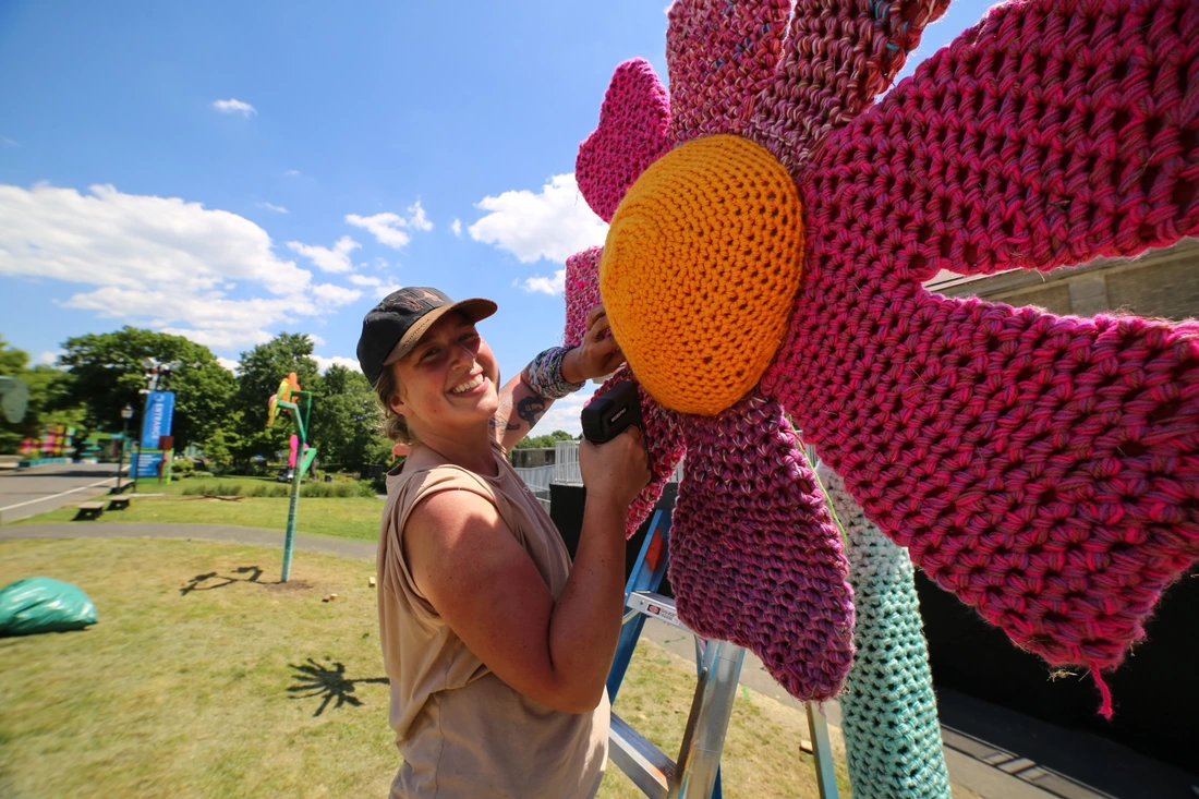 Installation shot of Nicole Nikolich, Lace in the Moon, and street artist Inphltrate installing a collaborative yarnbomb 